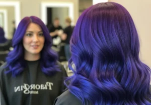 A woman happily getting the result of colored hair